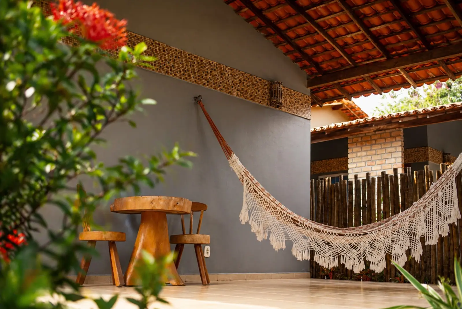 Varanda do chalé com rede e mesa de apoio no Rancho das Dunas